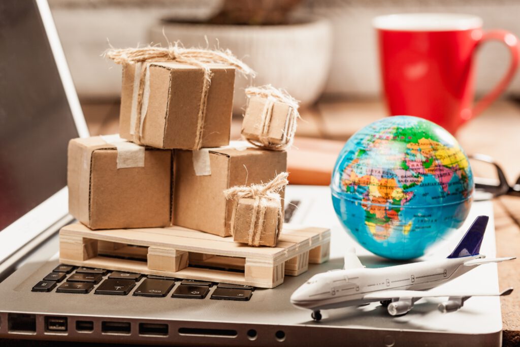 Kartonnen verzenddozen op een pallet met wereldbol en vliegtuig – wereldwijd producten verzenden.